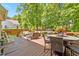 Large back deck with plenty of seating, an umbrella table and chairs, and a view of the yard beyond at 11 Smoketree Ct, Durham, NC 27712