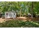 Backyard shed with a small window and double doors surrounded by trees and grass at 11 Smoketree Ct, Durham, NC 27712