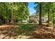 Large backyard with a back deck, mature trees, and a view of the back of the home at 11 Smoketree Ct, Durham, NC 27712