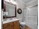Bathroom featuring a single sink vanity, a framed mirror, and a shower-tub combo with glass doors at 11 Smoketree Ct, Durham, NC 27712
