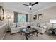 Bright living room with a large cream colored sectional couch and stylish black metal and glass coffee table at 11 Smoketree Ct, Durham, NC 27712
