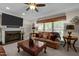 Comfortable living room featuring a fireplace, a ceiling fan, and large windows at 11 Smoketree Ct, Durham, NC 27712