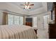 Lovely main bedroom with view of the ensuite bath, large windows, and mounted television at 11 Smoketree Ct, Durham, NC 27712
