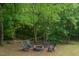 Outdoor firepit area with Adirondack chairs and string lights for a relaxing backyard space at 1101 Washhouse Ln, Wake Forest, NC 27587