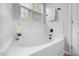 Clean bathroom featuring a soaking tub, white tile, and a bright window at 1101 Washhouse Ln, Wake Forest, NC 27587