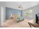 Bright bedroom with a large window, blue accent wall, and ceiling fan at 1101 Washhouse Ln, Wake Forest, NC 27587
