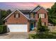 Charming two-story brick home with well-maintained landscaping, black shutters and two car garage at 1101 Washhouse Ln, Wake Forest, NC 27587