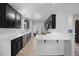 Well-lit kitchen with dark cabinets, stainless steel appliances, and a breakfast bar at 1101 Washhouse Ln, Wake Forest, NC 27587