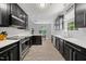 Modern kitchen with sleek black cabinets, stainless steel appliances, and subway tile backsplash at 1101 Washhouse Ln, Wake Forest, NC 27587