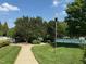 Manicured walking path with mature landscaping leads to community tennis courts in the distance at 1101 Washhouse Ln, Wake Forest, NC 27587