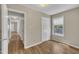 Bedroom with wood-look floors, a window, and a view of the hallway at 1112 Mark St, Raleigh, NC 27601