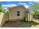 Rear exterior view of a vinyl sided house with an attached shed, wood fence and lush trees at 1112 Mark St, Raleigh, NC 27601