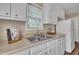 Clean kitchen sink area with white cabinets and neutral walls at 1112 Mark St, Raleigh, NC 27601