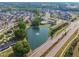 Residential community featuring a scenic pond with fountain, swimming pool, and surrounding homes at 112 Serenata Dr, Holly Springs, NC 27540
