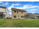 Back exterior of the home with a screened porch overlooking a green lawn at 112 Serenata Dr, Holly Springs, NC 27540
