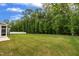 Well-maintained backyard with lush green lawn and privacy from mature trees at 112 Serenata Dr, Holly Springs, NC 27540