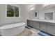 Bright bathroom with a modern soaking tub, double sink vanity, and a large window offering a peaceful view at 112 Serenata Dr, Holly Springs, NC 27540