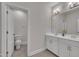 Stylish bathroom with a toilet, double sinks, and a white vanity at 112 Serenata Dr, Holly Springs, NC 27540