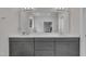 Double sink vanity with a large mirror, gray cabinets, and ample counter space at 112 Serenata Dr, Holly Springs, NC 27540