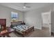 Bright bedroom with a ceiling fan, neutral walls, a desk, and a view from the window at 112 Serenata Dr, Holly Springs, NC 27540