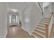 Inviting entryway with natural light, wood-look floors, and a glimpse of the staircase at 112 Serenata Dr, Holly Springs, NC 27540