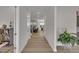 Bright hallway with hardwood floors, leading to the living room and kitchen, with neutral paint at 112 Serenata Dr, Holly Springs, NC 27540