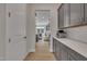 Hallway view toward the kitchen with gray cabinets and stainless steel appliances at 112 Serenata Dr, Holly Springs, NC 27540