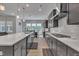 Spacious kitchen featuring modern gray cabinets, an island, and stainless steel appliances with eat in dining at 112 Serenata Dr, Holly Springs, NC 27540