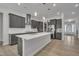 Open-concept kitchen with a large island, stainless steel appliances, gray cabinets, and pendant lighting at 112 Serenata Dr, Holly Springs, NC 27540