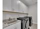 Convenient laundry room with modern washer and dryer, granite countertop, and plenty of storage at 112 Serenata Dr, Holly Springs, NC 27540
