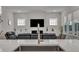 Living room view from the kitchen with fireplace and entertainment center, modern seating, and natural light at 112 Serenata Dr, Holly Springs, NC 27540