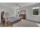 Comfortable main bedroom featuring a bed, dresser, and natural light, perfect for rest and relaxation at 112 Serenata Dr, Holly Springs, NC 27540