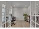 Bright office space with French doors, hardwood floors, a large window, and contemporary furnishings at 112 Serenata Dr, Holly Springs, NC 27540