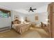 Bright bedroom with two beds, elegant furnishings, ceiling fan, and sunlit windows at 11470 Club Dr, Chapel Hill, NC 27517