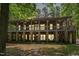 Spacious home featuring a double-decker porch, stone accents, and outdoor string lights, creating an inviting atmosphere at 11470 Club Dr, Chapel Hill, NC 27517