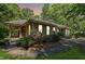 Beautiful home with a covered porch, vibrant flowers, and manicured landscaping, creating a serene outdoor setting at 11470 Club Dr, Chapel Hill, NC 27517