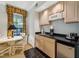 Convenient kitchenette featuring light cabinets, sleek black countertop, microwave, mini-fridge, and breakfast table at 11470 Club Dr, Chapel Hill, NC 27517