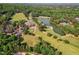 Expansive aerial view of lush golf course with lake, clubhouse, and neighborhood homes nestled within trees at 11475 Club Dr, Chapel Hill, NC 27517