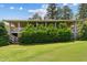 Expansive backyard view showcasing a covered porch and mature trees at 11475 Club Dr, Chapel Hill, NC 27517