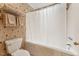 Bathroom with a tub and shower combination with decorative wallpaper and a toilet at 11475 Club Dr, Chapel Hill, NC 27517
