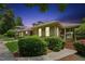 A beautifully landscaped home exterior featuring a covered porch and lush green shrubbery at 11475 Club Dr, Chapel Hill, NC 27517