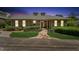 Inviting home with stone walkway, manicured lawn, and warm exterior lighting at dusk at 11475 Club Dr, Chapel Hill, NC 27517