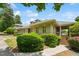 A beautifully landscaped home exterior featuring a covered porch and lush green shrubbery at 11475 Club Dr, Chapel Hill, NC 27517