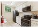 Cozy kitchen with white cabinets, black appliances, and a window providing natural light at 11475 Club Dr, Chapel Hill, NC 27517