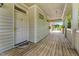 Inviting covered porch with wooden flooring leading to the front door of the house at 11475 Club Dr, Chapel Hill, NC 27517