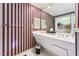 Bathroom with a double sink vanity, striped wallpaper, and a view into the closet at 11477 Club Dr, Chapel Hill, NC 27517