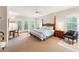 A bedroom with a four-poster bed, ceiling fan, sitting area, and a door to the outside at 11477 Club Dr, Chapel Hill, NC 27517