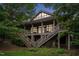 View of home featuring a two-story deck with stairs and a stone foundation during evening at 11477 Club Dr, Chapel Hill, NC 27517