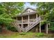 Exterior of home featuring a two-story deck with stairs and a stone foundation at 11477 Club Dr, Chapel Hill, NC 27517
