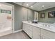 Bright bathroom featuring a double vanity with white cabinetry and a large mirror at 11483 Club Dr, Chapel Hill, NC 27517